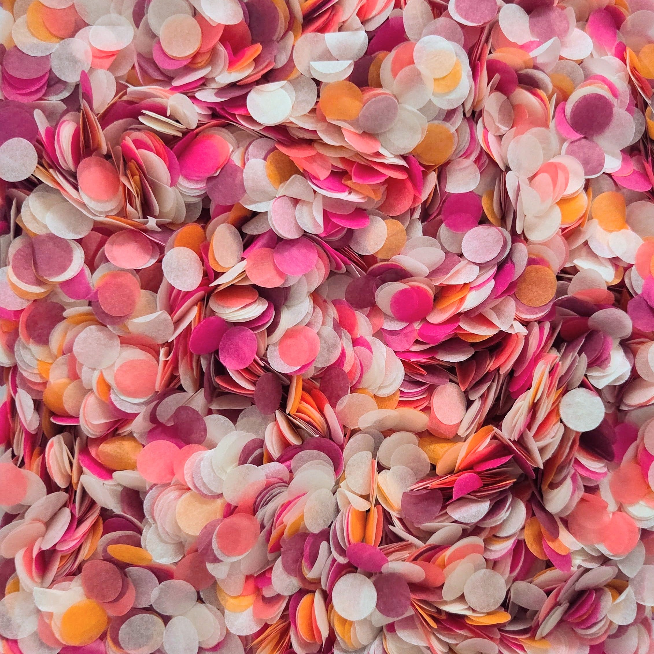 Full bloom confetti mix containing pinks, orange, burgundy and ivory paper confetti close up in detail